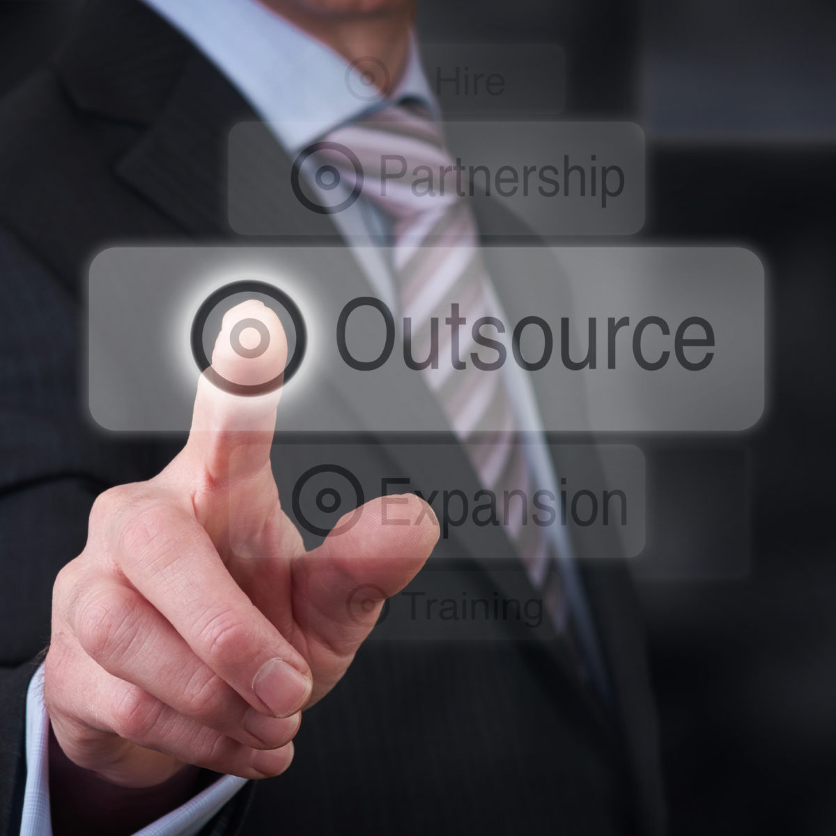 A businessman Pointing to a business outsourcing button on a clear screen.