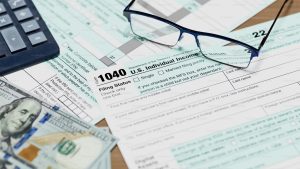 1040 tax document with glasses on a table